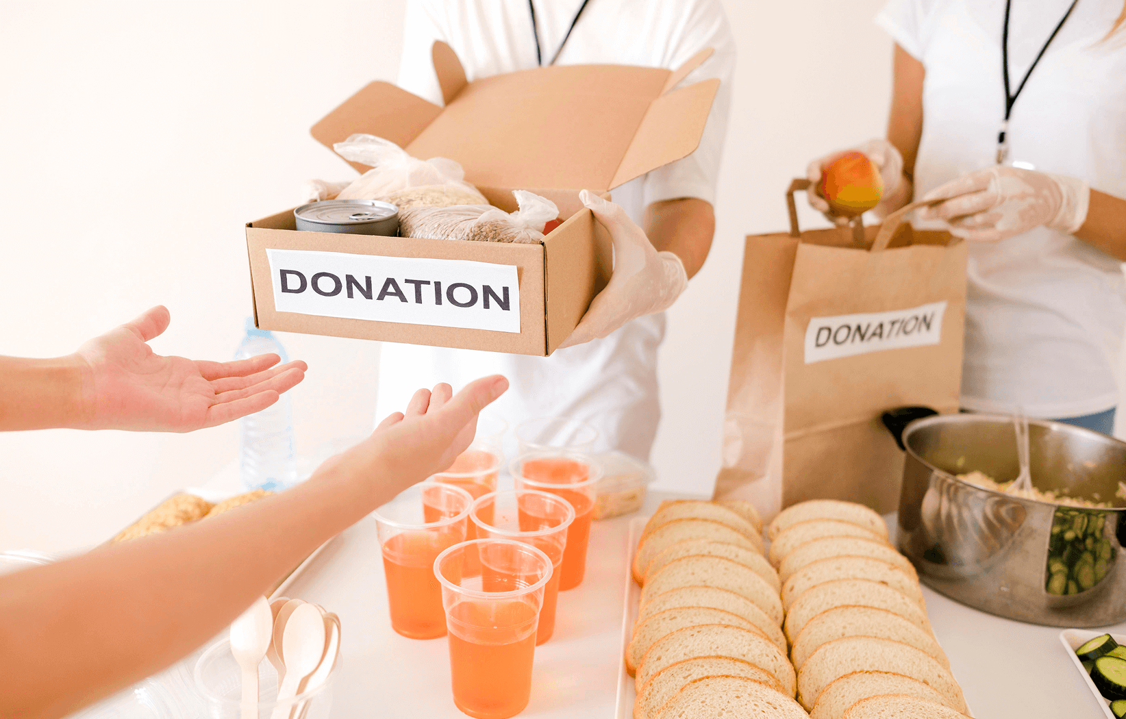Boxes and bags labeled donation containing food items like apples, cucumbers, jars, canned goods, and bottled water.