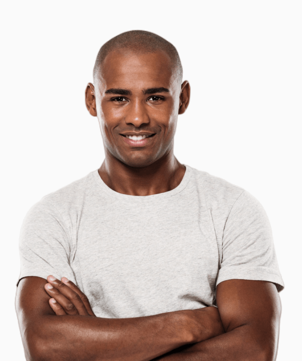 Smiling young man with crossed arms wearing a light gray t-shirt against a white background.