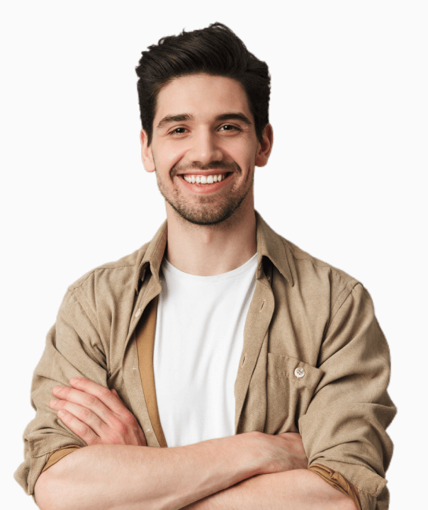 Smiling young man with dark hair, wearing a beige shirt over a white t-shirt, arms crossed.